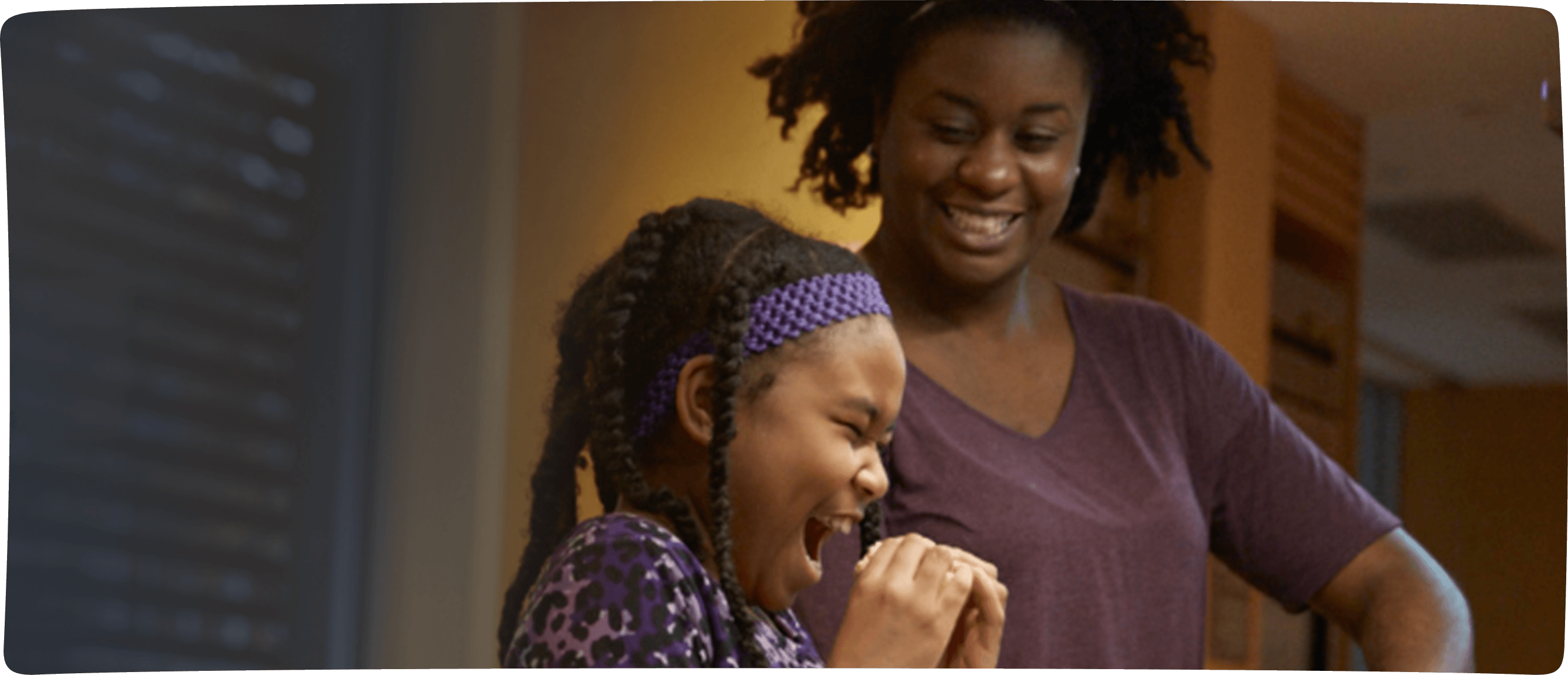 Mother and child laughing in a Ronald McDonald House kitchen.