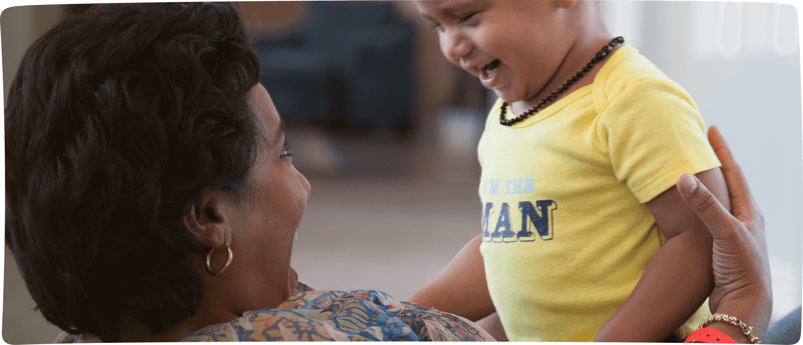 RMHC family, Antuane laying on her back holding her son Vasco Gonzales laughing from his seat atop mom